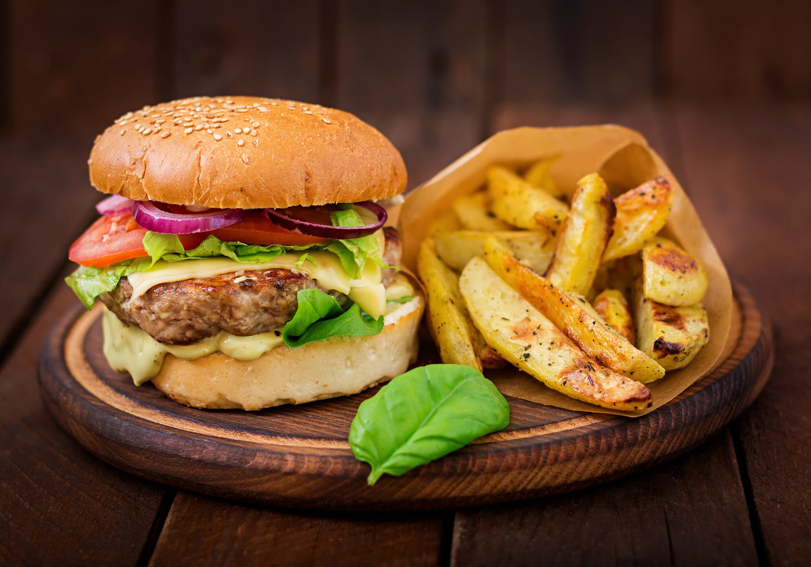 big-sandwich-hamburger-with-juicy-beef-burger-cheese-tomato-and-red-onion-on-wooden-table.jpg